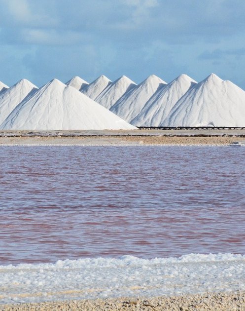 White salt pyramids above pink water at the Pekelmeer salt flats