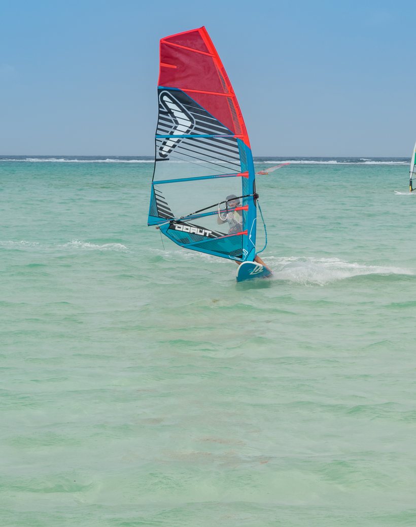 Windsurfers on the shallow turquoise lagoon of Lac Bay